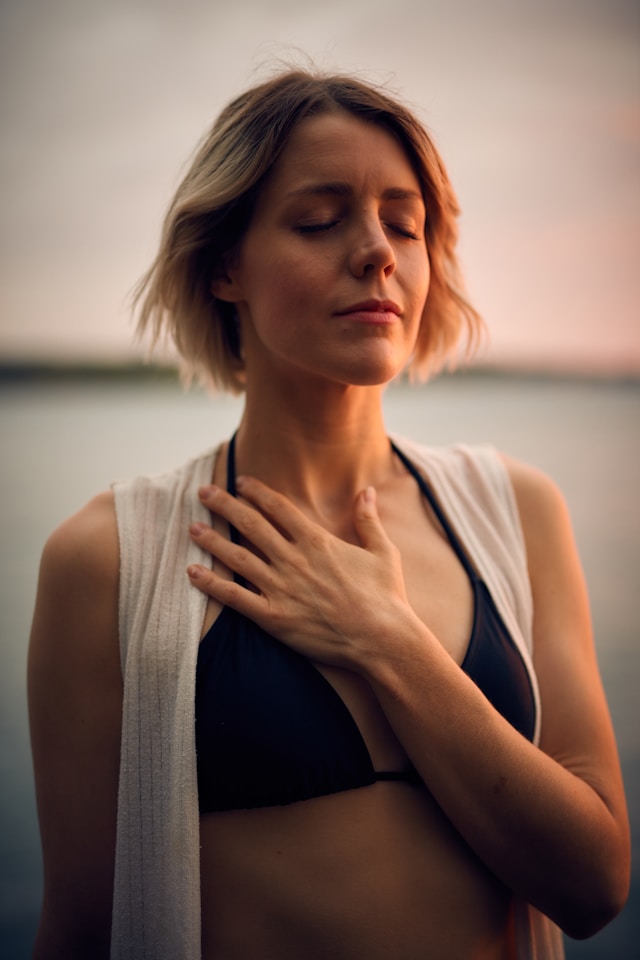 Woman with hand on heart releasing tension through somatic body awareness